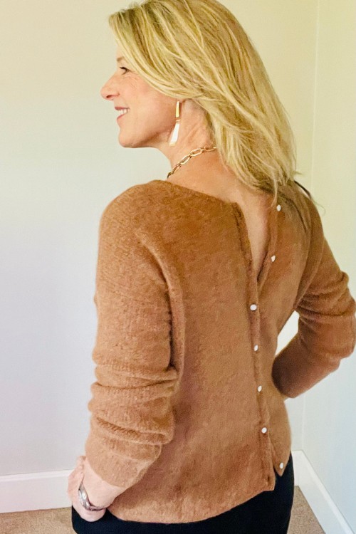 Susan Heinrich wears a French style basic, a classic cardigan. She is wearing a camel cardigan by Sezane with the buttons at the back.