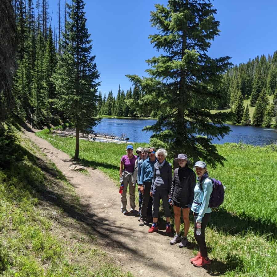 A group of seven midlife women on a hiking trail in Colorado.