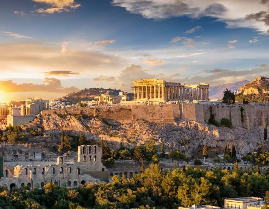 The Athens Acropolis up on a hill overlooking the city, with the setting sun casting a golden light