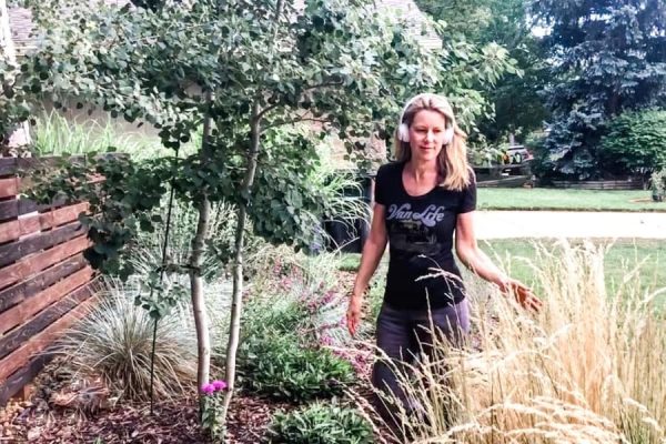 Susan Heinrich walking through a garden with headphones on