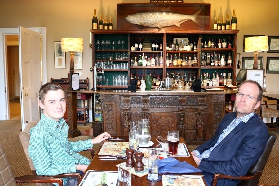 A man and his son sit at at a table in a country hotel in Scotland