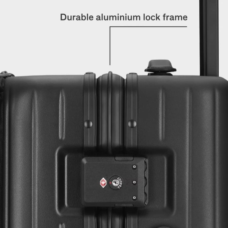 A close up side view of black luggage showing the lock closure.