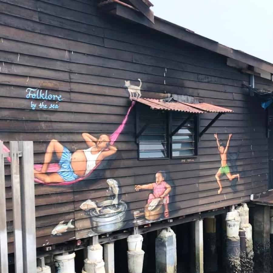 A mural painted on a building on the Chew Jetty depicts a family enjoying an afternoon by the water
