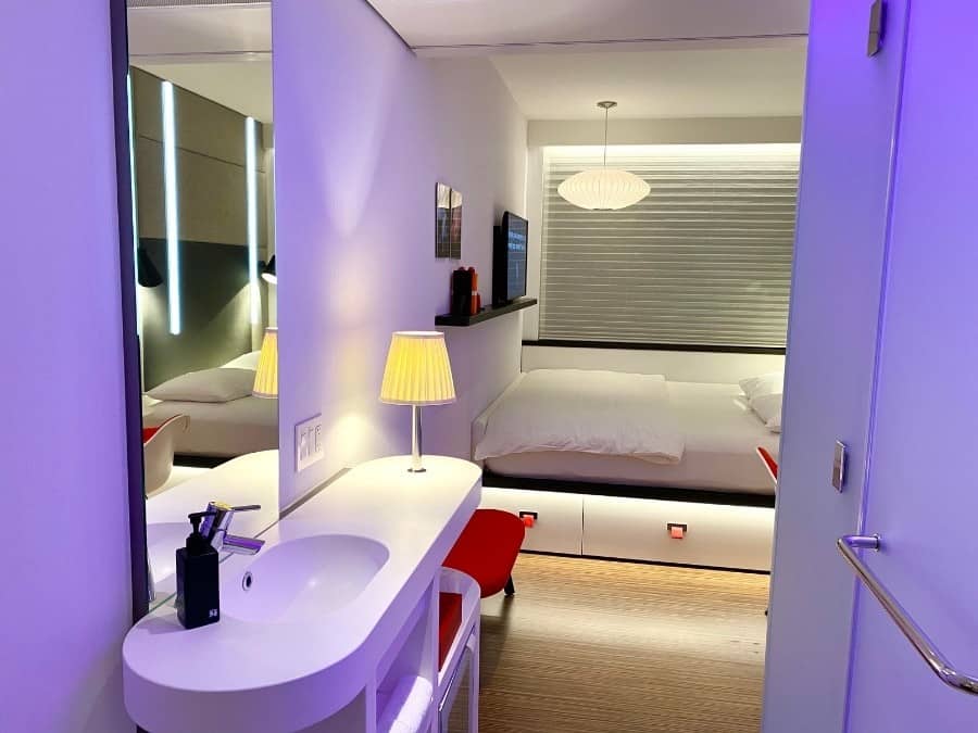 A hotel room at CitizenM Bowery Hotel in new York with modern design and purple lighting