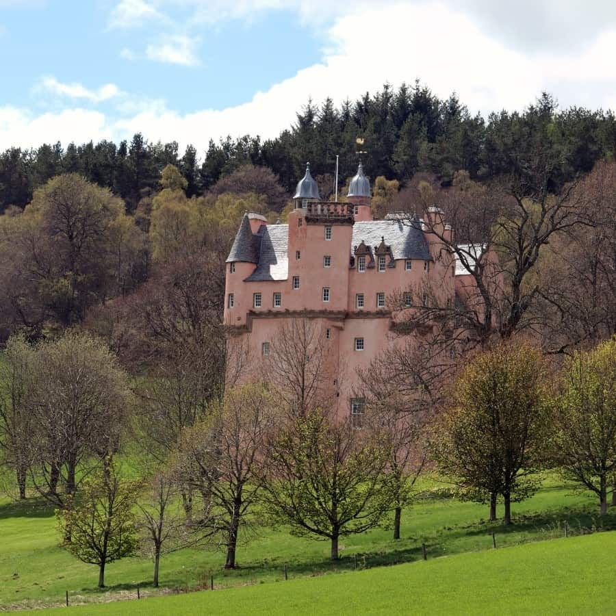 Craigievar Castle, a lovely pink hue and set among trees
