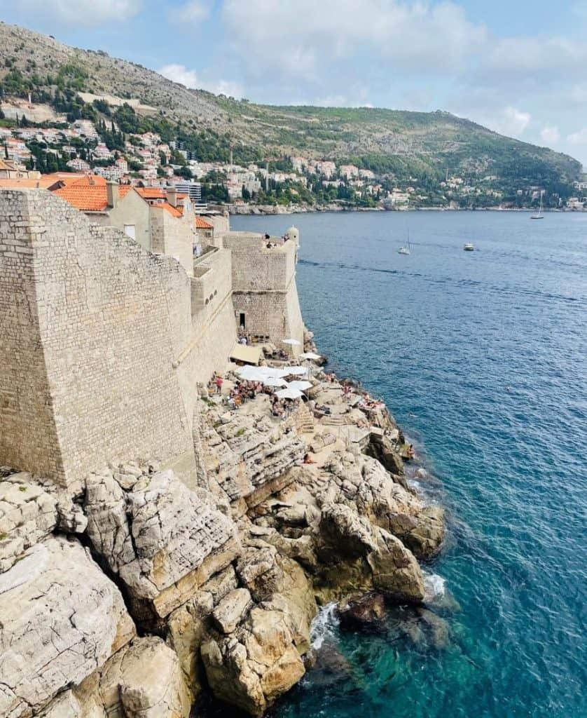 Walls of old city Dubrovnik set next to the Adriatic Sea, with some of the city visible beyond