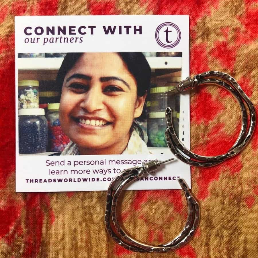 A pair of earrings with a picture of the woman who made them, by Threads Worldwide