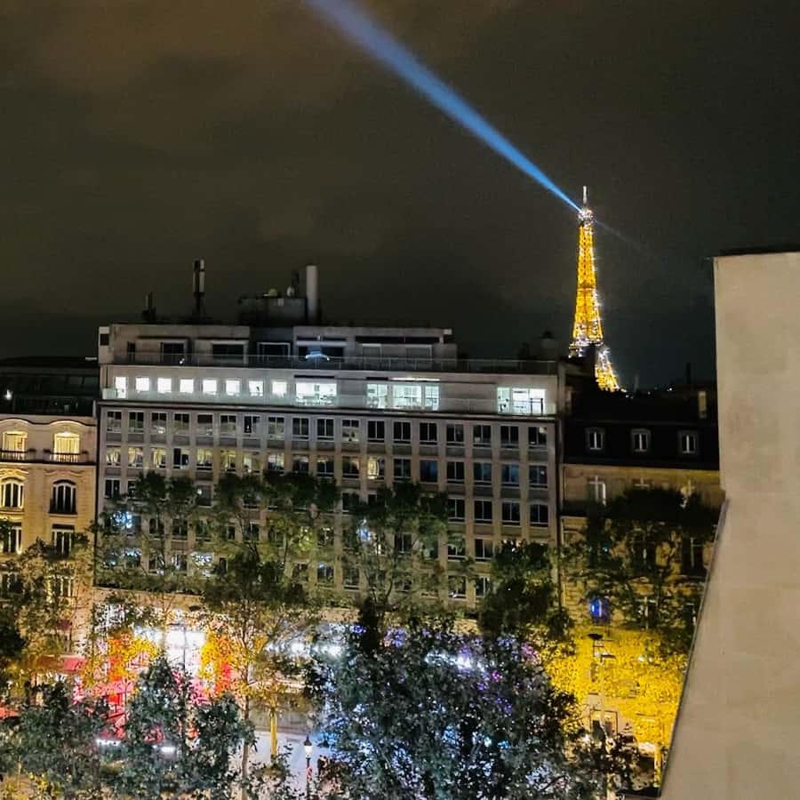 The Champs Elysees at night and an Eiffel Tower view in the distance