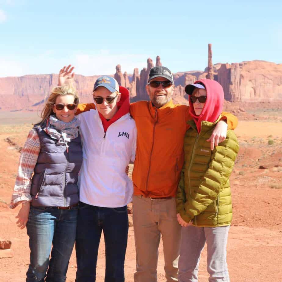 Susan Heinrich stands with her teens and husband in front of Sandstone Buttes in Monument Valley, Arizona.