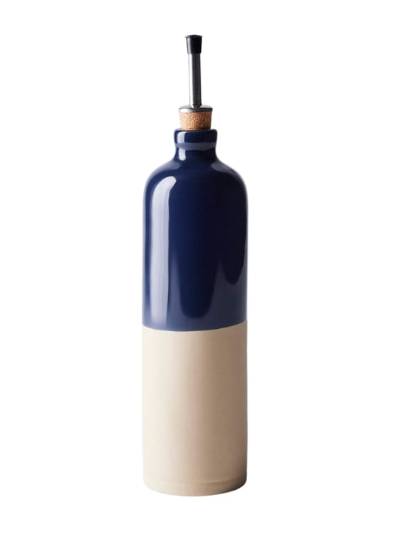 A French Oil Cruet, a tall clay bottle with a spout. It is creme and navy colored.