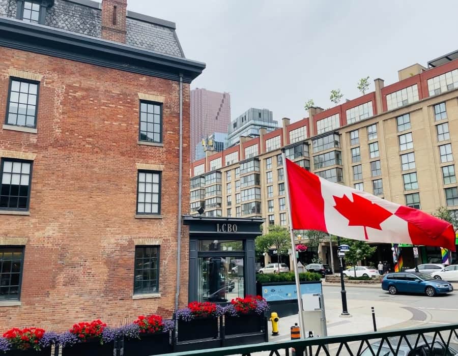 Front Street Toronto with a mix of historic and new building and a Canadian flag