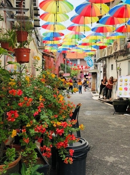 A colourful street with umbrellas at its top in Penang