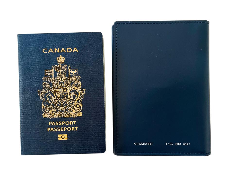 A blue passport wallet is pictured next to a Canada passport