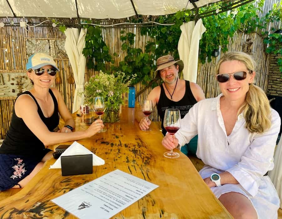 Susan Heinrich at a winery in Greece with Cory Henry and Ashley Blake, founder of Traverse Journeys.