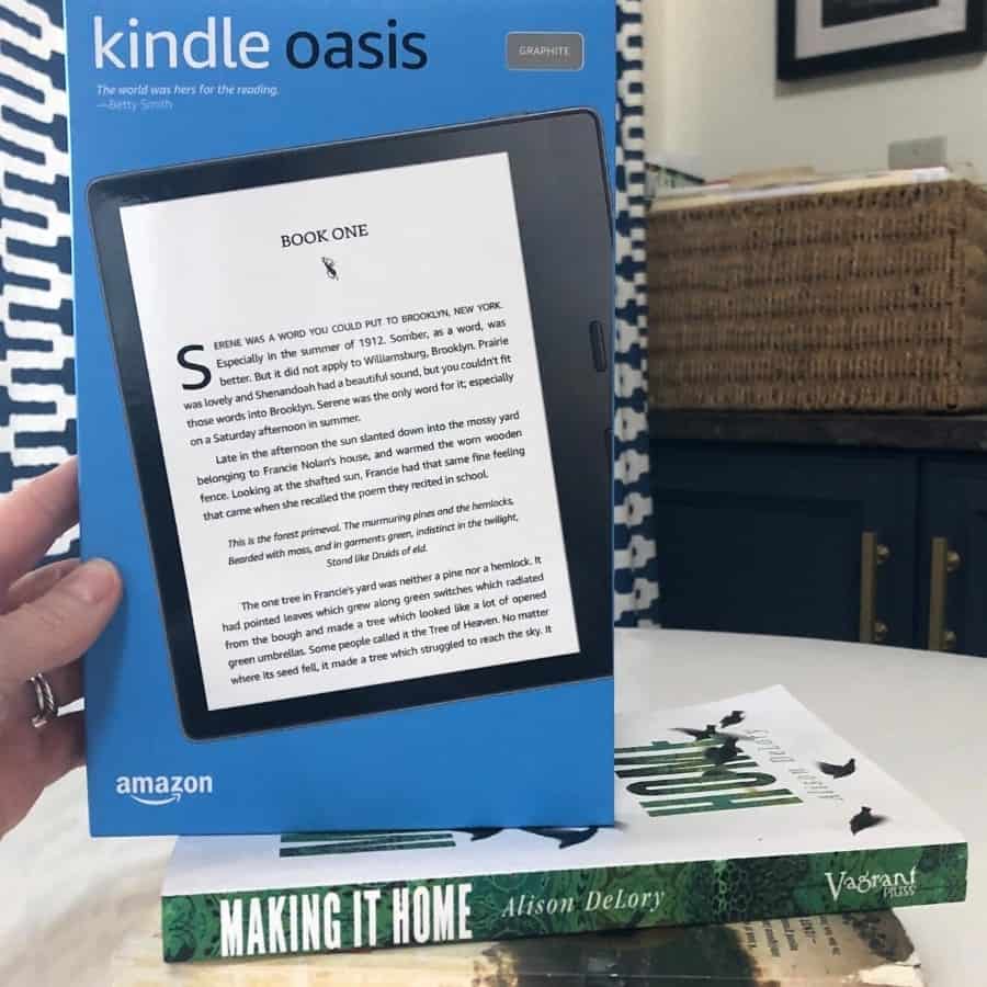 The Kindle Oasis E-reader sits on a pile of books