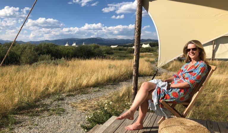 midlife woman sits in glamping tent in Montana