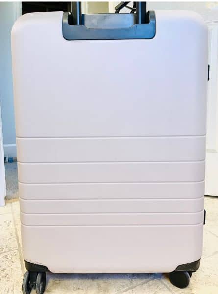 The Monos Medium checked bag in desert taupe, a light beige, pictured after being cleaned. The scuffs are gone; it looks almost like new.