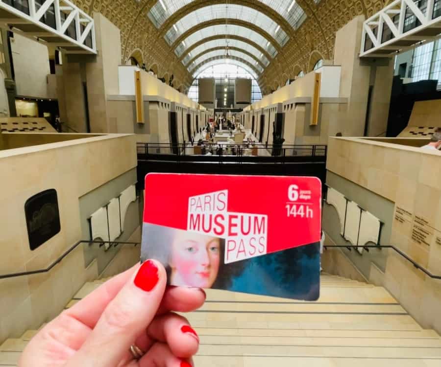A hand holds the Paris Museum Pass at the Musee d'Orsay
