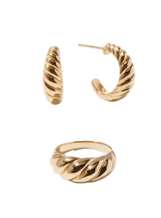 Jewelry by online retailer Quince. Pictured are earrings and a ring in a subtle shape of a croissant and finished in gold vermeil.