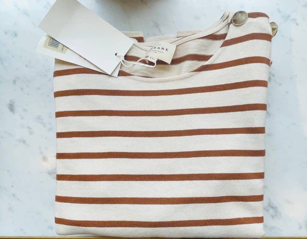 Sézane's Colette Mariniere shirt is on display at a Sezane store in Paris. It is ecru with camel stripes.