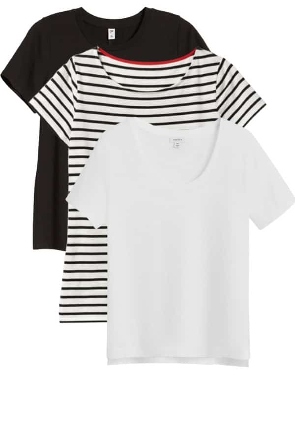 Three t-shirts in a stacked pile: white, black and striped, are staples of a spring capsule wardrobe