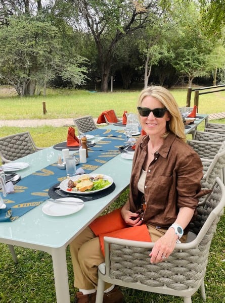 Susan Heinrich sits at a lunch outdoors at Leroo la Tau safari lodge, Botswana.
