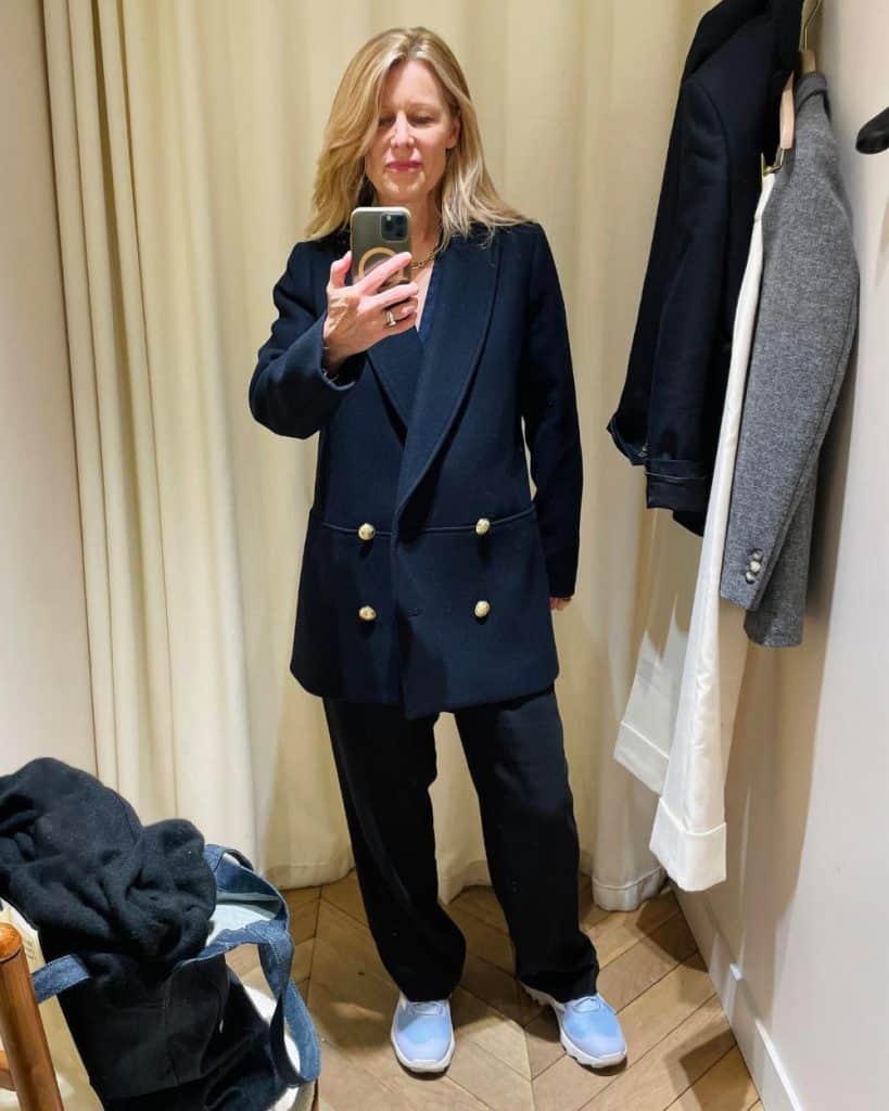 Susan trying on the navy James Coat at Sézane Paris in Le Marais.