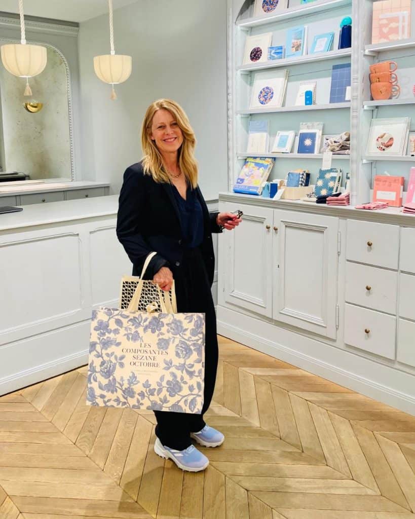 Susan Heinrich holds a large Sézane shopping bag at the checkout counter at the Paris store in Le Marais.