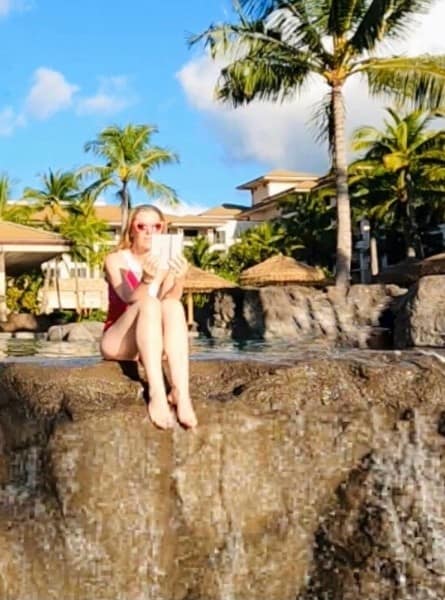 Susan Heinrich reads a kindle e-reader in the pool at the Westin Nanea Ocean Villas