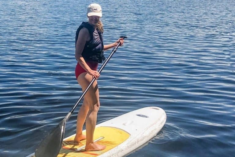 Susan on a stand-up paddle board in her life after a hip replacement