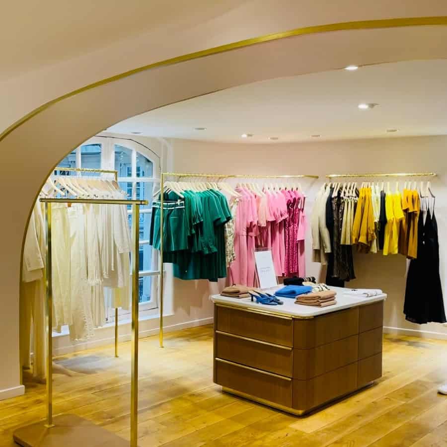 The Tara Jarmon Store in Paris with an arched ceiling and a rack of clothes hanging by colour