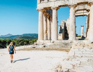 Ashley Blake, founder of Traverse Journeys walks next to the Temple of Aphaia in Greece