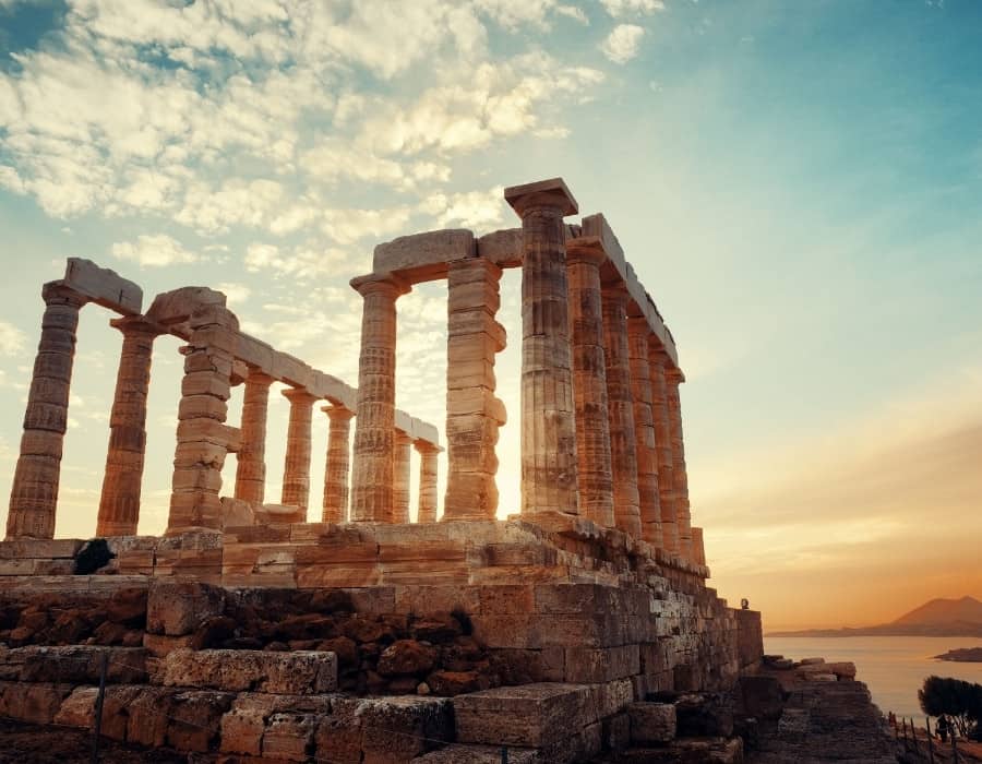The Temple of Poseidon set at the Aegean Sea, glows at sunset. About 1.5 hours from the Greek capital, it makes a perfect day trip from Athens