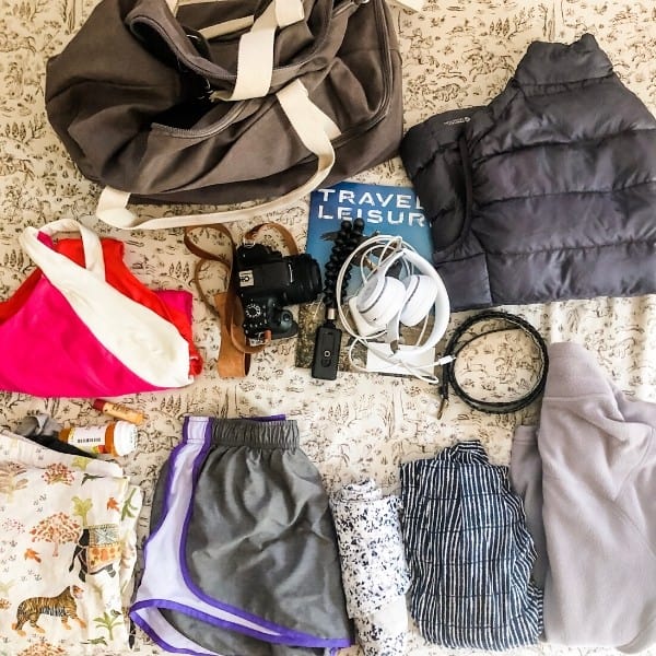 clothes and travel items are laid out to be packed